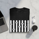 Black t-shirt with white equalizer sliders graphic, next to laptop and earbuds.
