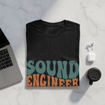 Dark t-shirt with wavy "SOUND ENGINEER" text in teal and orange.